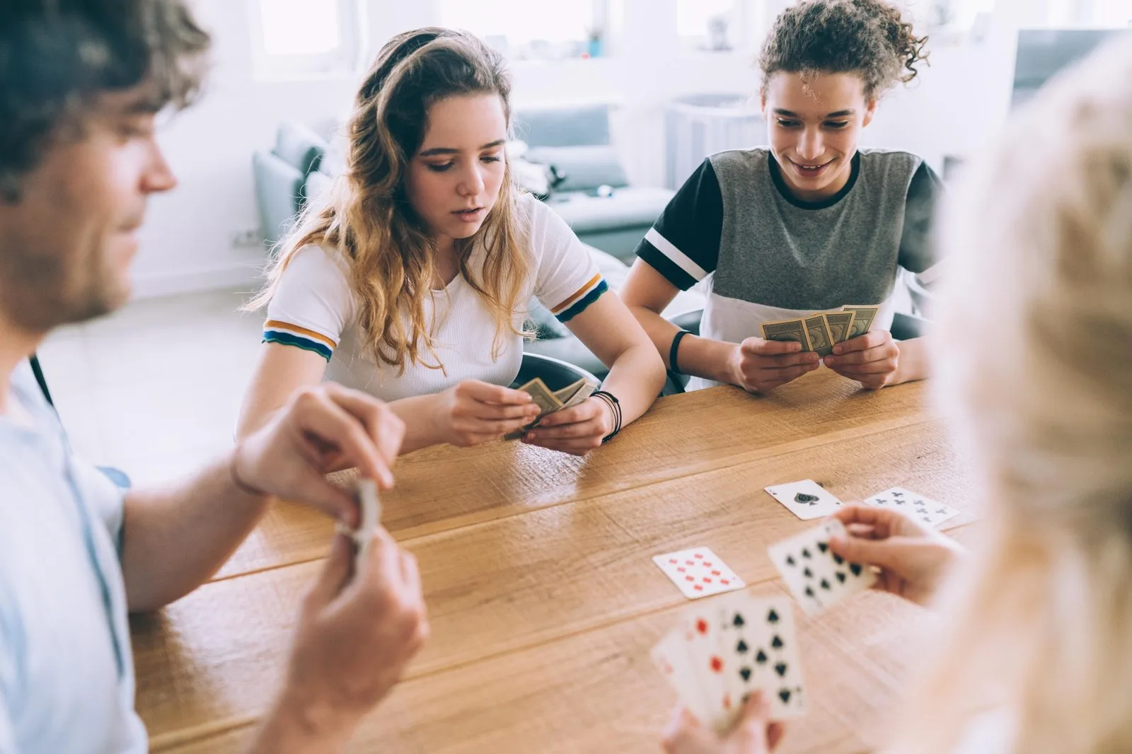 Familj spelar klassiskt kortspel vid köksbordet